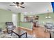 Open-concept living space with a view of the kitchen, featuring hardwood floors, cozy seating, and modern lighting at 174 Dorothy Dr, Charleston, SC 29414