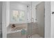 Bright bathroom featuring a soaking tub under a window and glass-enclosed shower at 1784 Omni Blvd, Mount Pleasant, SC 29466