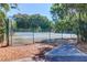 Outdoor tennis court surrounded by lush greenery and a secure fence at 1784 Omni Blvd, Mount Pleasant, SC 29466