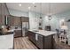 Spacious kitchen featuring stainless appliances, large island with sink, gray cabinetry, hardwood floors, and open layout at 2006 Barn Swallow Rd, Summerville, SC 29483