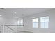 Bright hallway showcasing a dark railing, multiple windows, and hardwood flooring at 2010 Mcguire Ln # 003, Hollywood, SC 29449