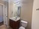 This bathroom features a functional layout with a brown vanity, white sink, toilet, and vanity mirror at 203 Goldfinch Ln, Summerville, SC 29485