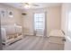 Neutral bedroom with a ceiling fan, a white crib, and a dresser by a window with sheer curtains at 203 Goldfinch Ln, Summerville, SC 29485