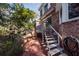 Brick patio with stairway, framed by brick exterior and lush backyard greenery at 210 Lakeview Dr, Summerville, SC 29485