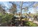 Lush backyard showcasing mature trees, landscaping, and a glimpse of a community pool at 210 Lakeview Dr, Summerville, SC 29485