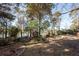 Tranquil backyard features mature trees and path with lake view beyond at 210 Lakeview Dr, Summerville, SC 29485