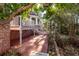 Brick patio beneath a deck, surrounded by trees and lush vegetation at 210 Lakeview Dr, Summerville, SC 29485