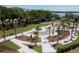 Aerial view of a new park-like green space with walkways, palm trees, and seating areas near a waterfront at 217 King George St, Daniel Island, SC 29492