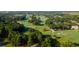 Expansive aerial view of a meticulously maintained golf course, surrounded by lush trees and elegant homes at 217 King George St, Daniel Island, SC 29492