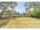 Spacious backyard featuring a black fence and trees overlooking a scenic waterfront view at 217 King George St, Daniel Island, SC 29492