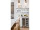 Charming bar area featuring a wine refrigerator, tile backsplash, and shelving for glassware and decor at 217 King George St, Daniel Island, SC 29492