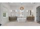 This bathroom's dual vanity and soaking tub with a modern light fixture adds elegance at 217 King George St, Daniel Island, SC 29492