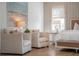Cozy bedroom featuring two armchairs, an art piece, and a comfy bed near a bright window at 217 King George St, Daniel Island, SC 29492