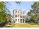Elegant three-story home with multiple balconies, a spacious yard and ground level patio at 217 King George St, Daniel Island, SC 29492