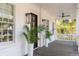 Charming front porch with wooden floors, featuring classic white columns, plants, and outdoor ceiling fan at 217 King George St, Daniel Island, SC 29492