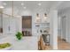 Bright kitchen featuring white cabinetry, marble countertops, and a wine refrigerator perfect for entertaining guests at 217 King George St, Daniel Island, SC 29492