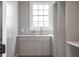 The spacious laundry room features modern gray cabinetry, a gold faucet, and a bright window at 217 King George St, Daniel Island, SC 29492