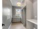 Well-lit laundry room with gray cabinets, stylish wallpaper, and ample countertop space at 217 King George St, Daniel Island, SC 29492