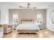 Serene main bedroom with a bright chandelier, wood accents and plenty of natural light streaming through two windows at 217 King George St, Daniel Island, SC 29492