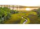 Elevated view of a winding creek in a marsh leading to a bridge over the river, highlighting the waterfront access at 217 King George St, Daniel Island, SC 29492