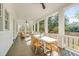 Spacious covered porch with stylish seating and a large table, perfect for outdoor dining and relaxation at 217 King George St, Daniel Island, SC 29492