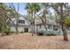 Rear exterior with a large wooden deck that is surrounded by lush trees at 2413 High Hammock Rd, Seabrook Island, SC 29455