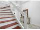 Staircase with wooden steps, white railings, and decorative mosaic-tiled landing at 2413 High Hammock Rd, Seabrook Island, SC 29455