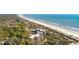 Scenic aerial view of a beachfront building with a tree-lined coastline, and ocean in the background at 2473 Shipwatch Rd, Kiawah Island, SC 29455