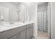 Clean bathroom featuring double sinks, gray cabinets, and a separate shower with blue curtains at 2710 Mcfadden Way, Johns Island, SC 29455
