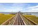 Wooden pier leading to a gazebo on the water, set against a scenic backdrop of sky and water at 2710 Mcfadden Way, Johns Island, SC 29455