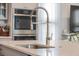 Close up of kitchen island features stainless steel faucet, sink and white quartz countertop with seating for guests at 2710 Mcfadden Way, Johns Island, SC 29455