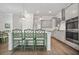 Bright kitchen with stainless appliances, shaker cabinets, white backsplash, island with seating, and modern lighting at 2710 Mcfadden Way, Johns Island, SC 29455