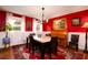 Inviting dining room featuring a stylish marble table, piano, and striking red accent wall with elegant decor at 29 Meander Row, Charleston, SC 29412