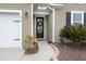 Close-up of the home's front door with wreath and a portion of the 2-car garage and landscaping at 319 Knawl Rd, Moncks Corner, SC 29461