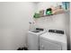 A functional laundry room featuring a front loading washing machine and dryer with overhead storage shelves at 319 Knawl Rd, Moncks Corner, SC 29461