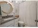 Cozy bathroom with granite countertop, shower with curtain, and a round gold framed mirror at 3563 Bayden Bridge Ln, Mount Pleasant, SC 29466