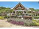 Community pool entrance featuring beautiful landscaping and covered area with brick columns and wooden beams at 3563 Bayden Bridge Ln, Mount Pleasant, SC 29466