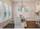 Dining area with wooden table, chair covers, modern chandelier, and sunlit shuttered windows at 3563 Bayden Bridge Ln, Mount Pleasant, SC 29466