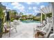 Inviting backyard pool area with outdoor seating and elegant white tile, perfect for entertaining and relaxation at 3563 Bayden Bridge Ln, Mount Pleasant, SC 29466