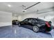 Garage featuring epoxy floors and a black four-door sedan with a gray sports car in the background at 4263 Hugh Bennett Dr, Johns Island, SC 29455