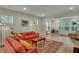 Bright living room featuring a comfortable orange sofa, decorative rug, and natural light from large windows at 4263 Hugh Bennett Dr, Johns Island, SC 29455