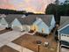 Drone view of a charming light blue one-story home with an attached garage and a grey roof at 455 Hidden Meadow Ln, Summerville, SC 29486