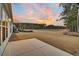 Backyard view from patio showcasing a large lawn and pond with wooded backdrop at sunset at 455 Hidden Meadow Ln, Summerville, SC 29486