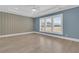 Bright bedroom with decorative wallpaper, tray ceiling, and white plantation shutters at 455 Hidden Meadow Ln, Summerville, SC 29486