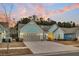 View of a charming one-story home with light blue siding and a two-car garage, set against a colorful sunset backdrop at 455 Hidden Meadow Ln, Summerville, SC 29486