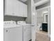 Laundry room featuring a washer and dryer set with upper cabinets, and an adjacent bathroom at 455 Hidden Meadow Ln, Summerville, SC 29486