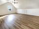 Bright attic space features hardwood floors, a ceiling fan, and a small window for natural light at 503 Middleton Blvd, Summerville, SC 29485