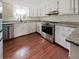 Well-lit kitchen featuring stainless steel appliances, white cabinets, and hardwood floors at 503 Middleton Blvd, Summerville, SC 29485