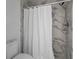 Modern shower with marble tile and a white shower curtain at 700 Daniel Ellis Dr # 8108, Charleston, SC 29412