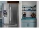 Bright kitchen featuring stainless steel refrigerator, built-in shelves, and painted blue cabinetry at 700 Daniel Ellis Dr # 8108, Charleston, SC 29412